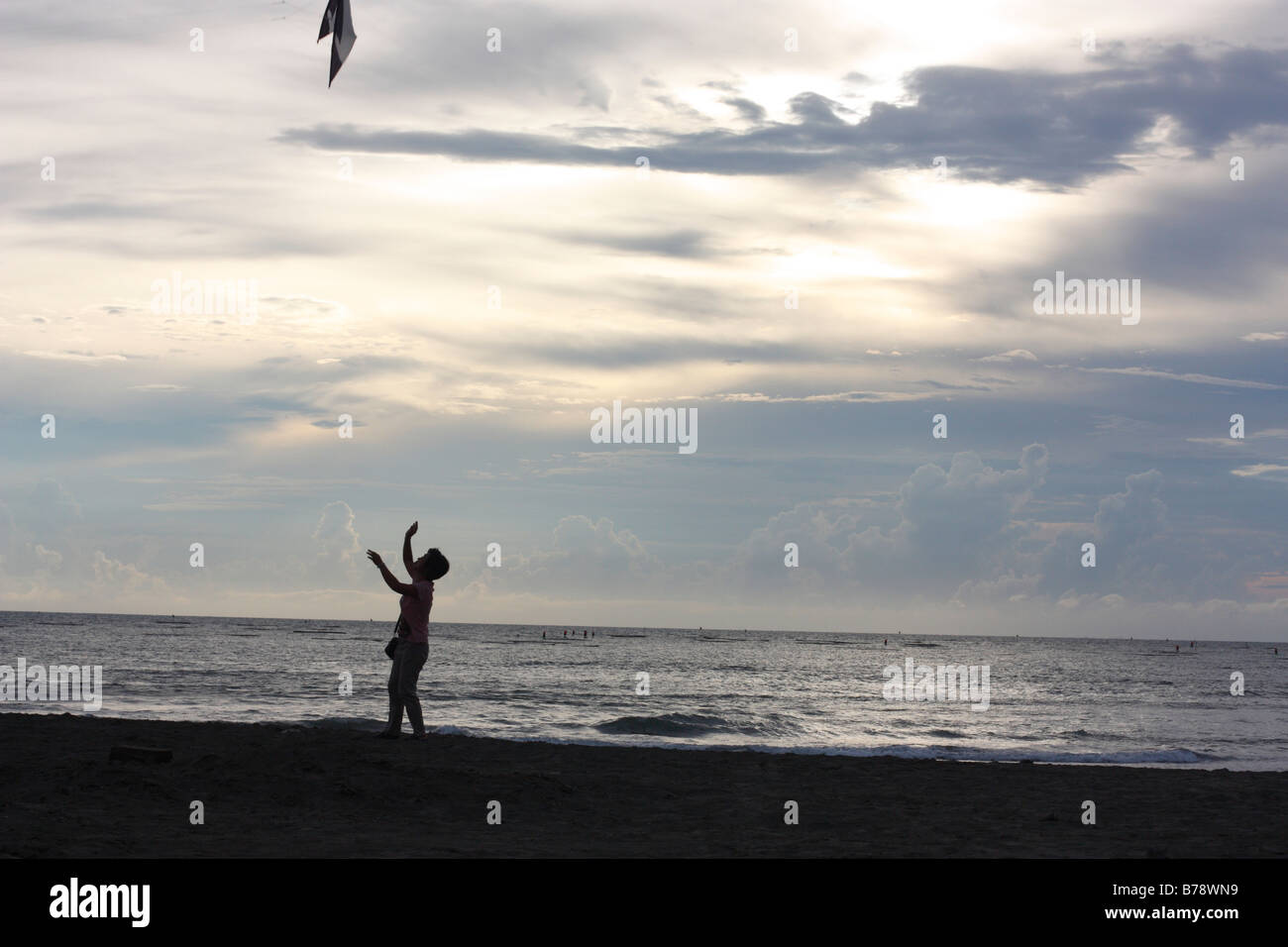 Woman letting go of a kite. Stock Photo