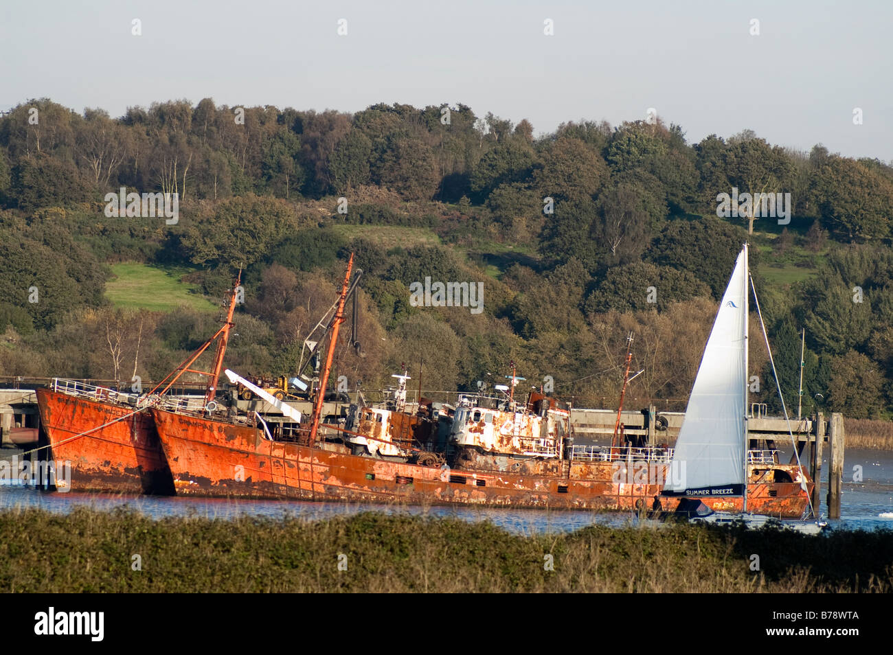 Two shipwrecks passed by sailing boat Stock Photo