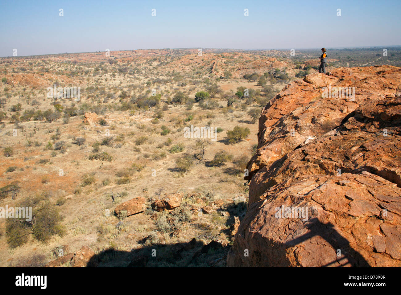 A tourist standing on a cliff overlooking the arid Limpopo River valley landscape Stock Photo