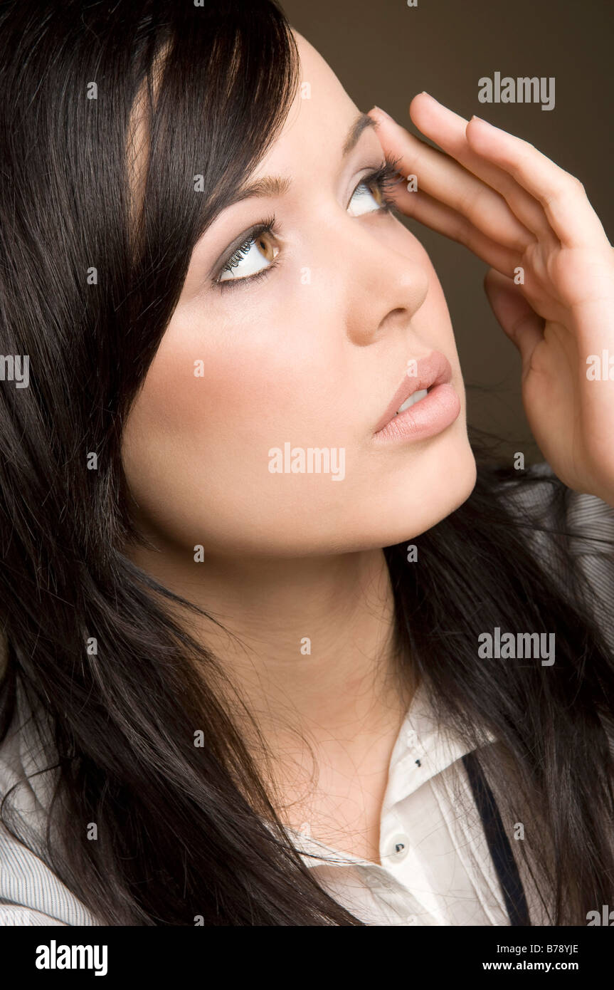 Young woman with hand on face, portrait, close-up Stock Photo