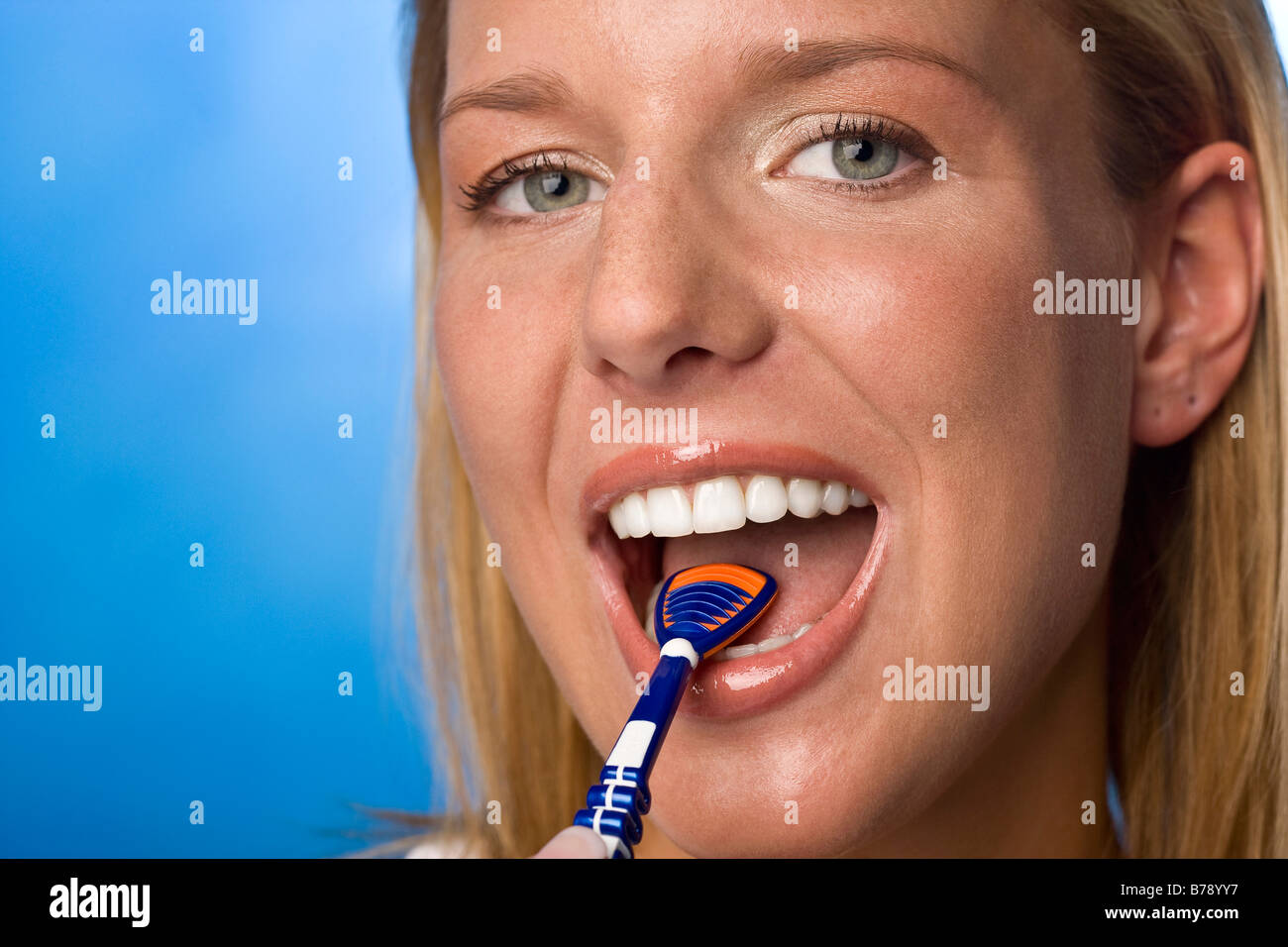 Young woman using tongue cleaner, portrait Stock Photo Alamy