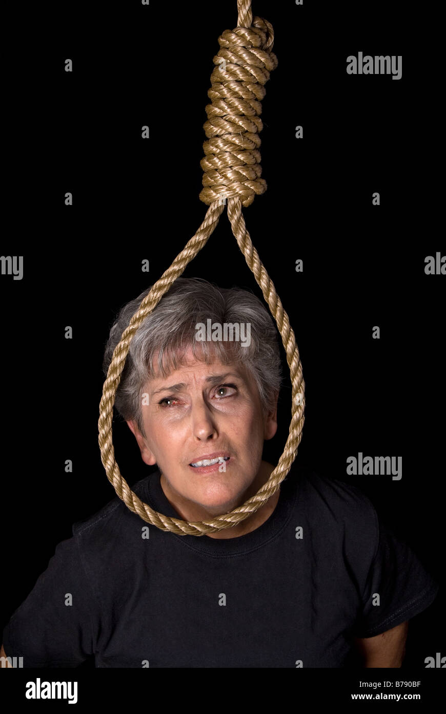 An elderly woman prepares to commit suicide by hanging Stock Photo