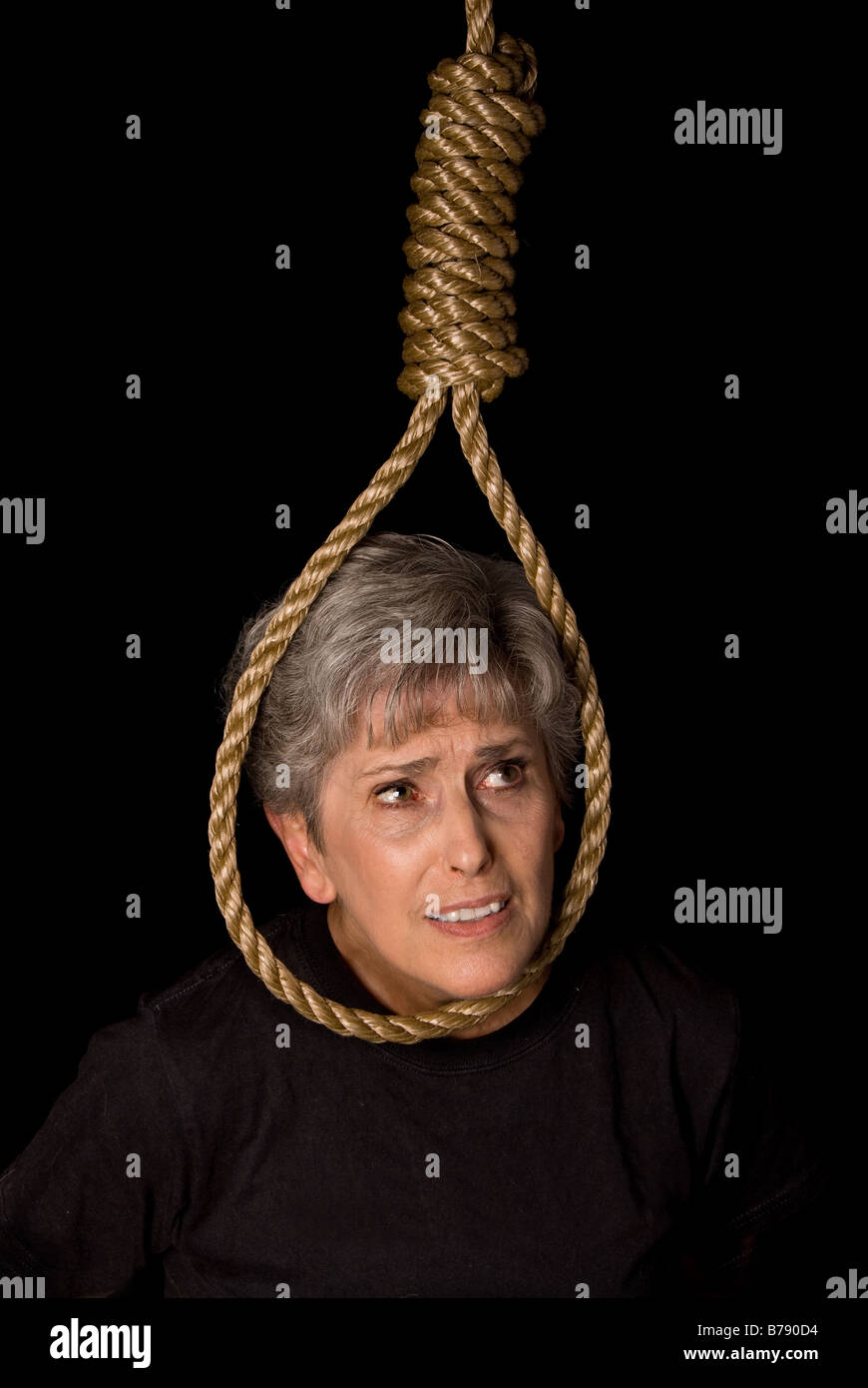 A depressed elderly woman prepares to commit suicide Stock Photo