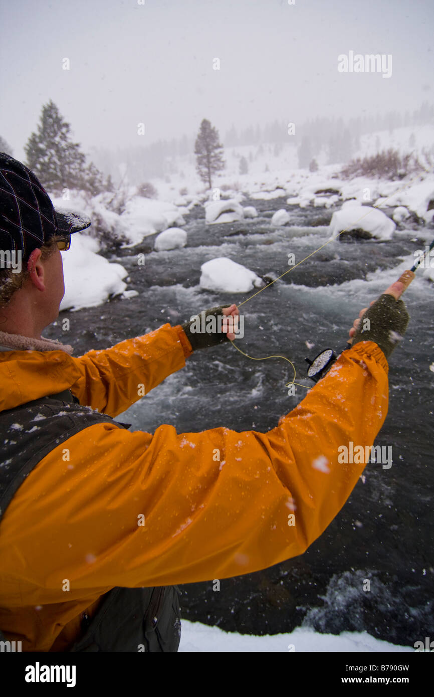 A man fishing on a snowy winter day on the Truckee River in California Stock Photo