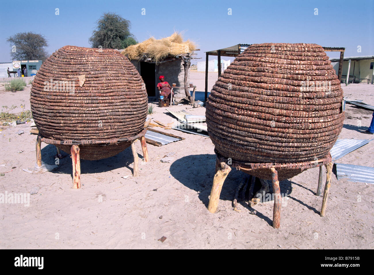Baskets for storage of grains, Wamob woman behind, Ovamboland, Namibia, Africa Stock Photo