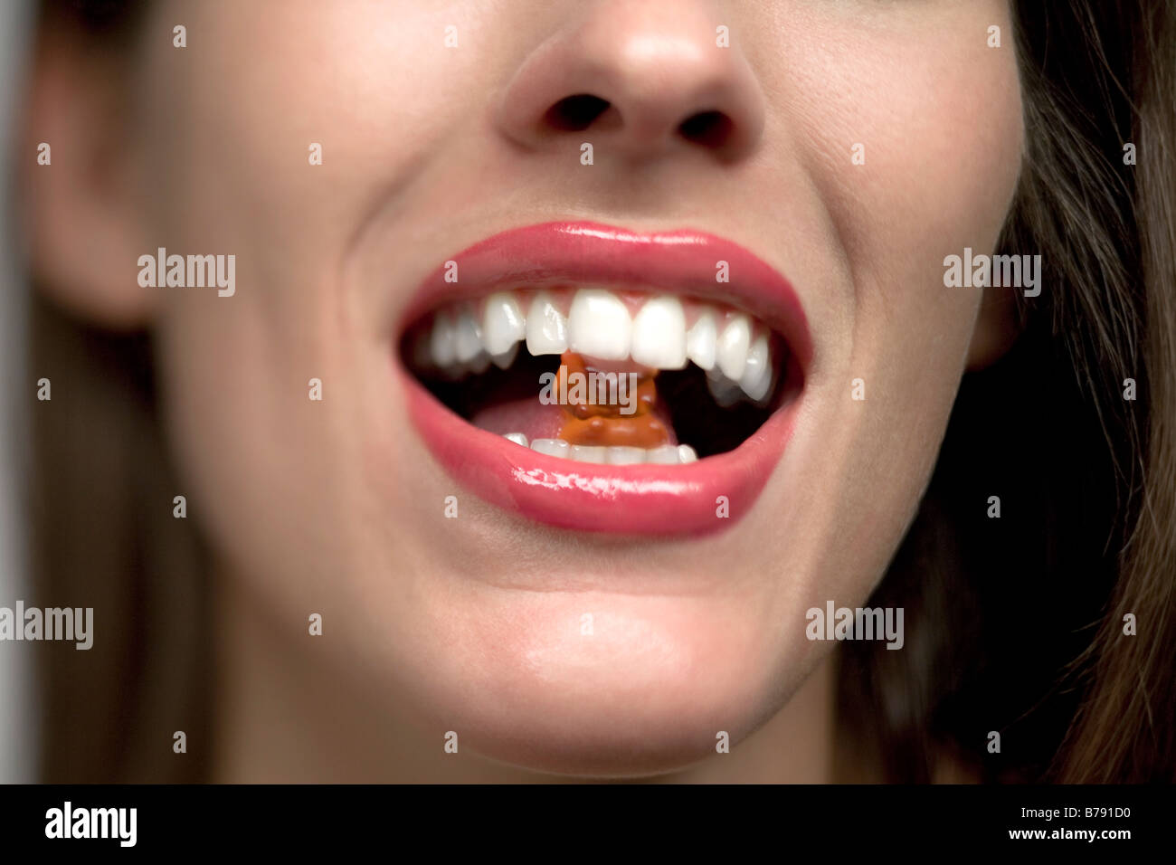 Young woman with gummi bear in mouth, portrait Stock Photo Alamy