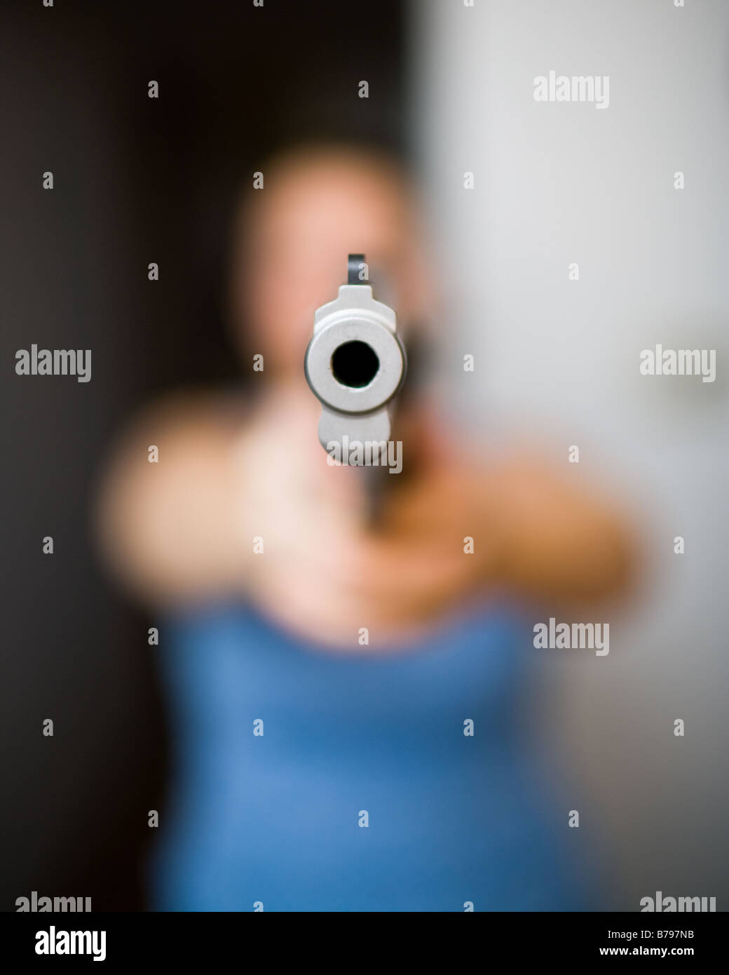 A woman points a gun Stock Photo