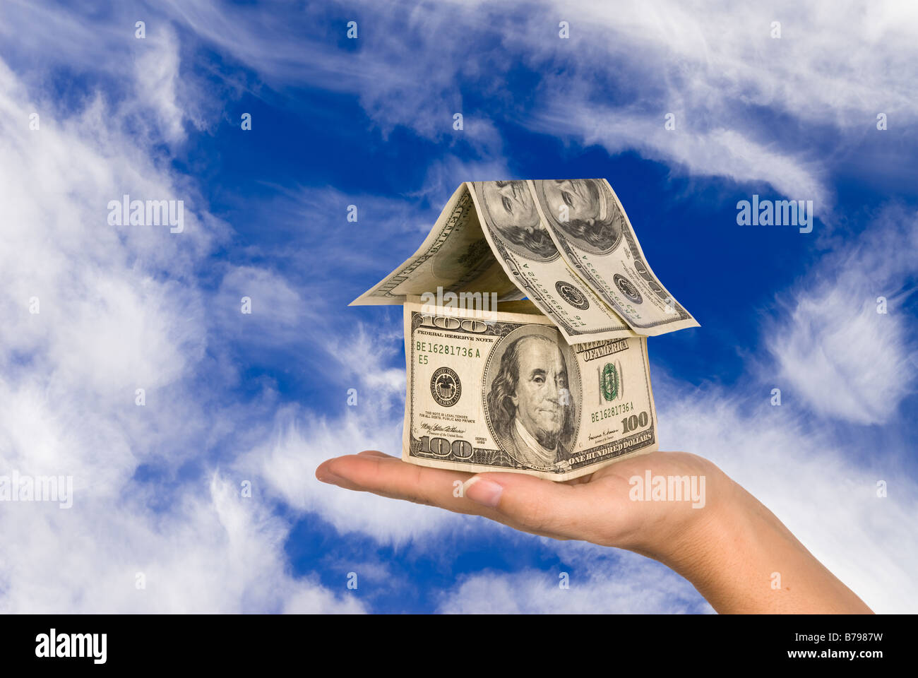 A conceptual real estate and economic inference image showing a one hundred dollar bill house Stock Photo