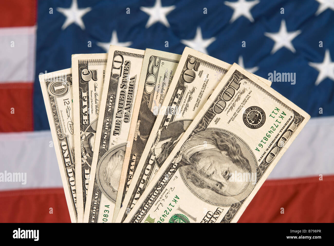 American currency against an American flag backdrop Stock Photo