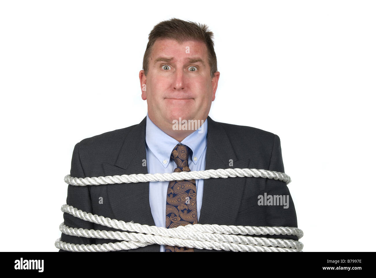 A businessman is tied up by his co workers Stock Photo