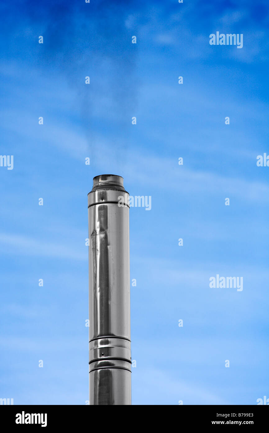 Smoking steel chimney against blue sky Stock Photo - Alamy