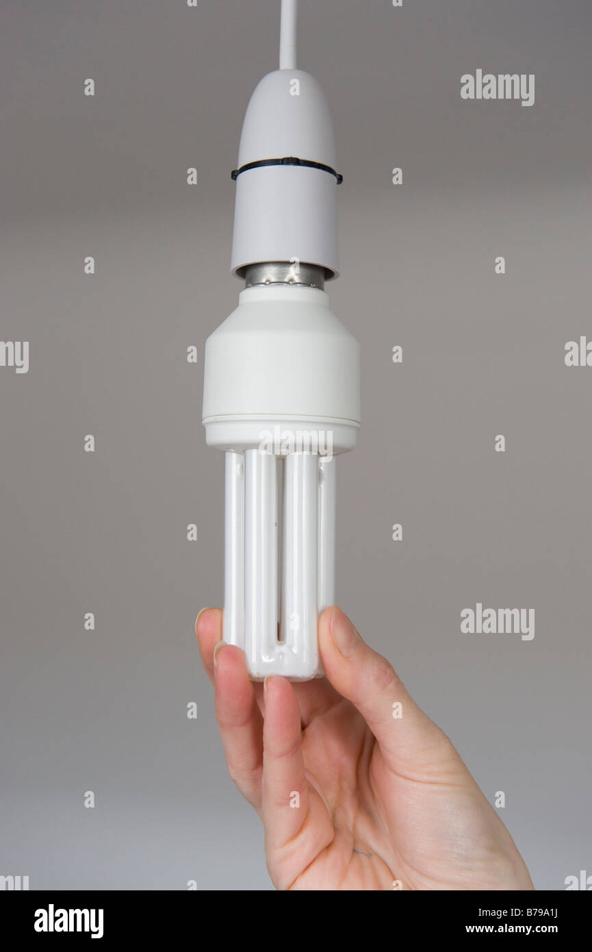 An Energy Efficient Light Bulb Being Plugged Into A Ceiling Light