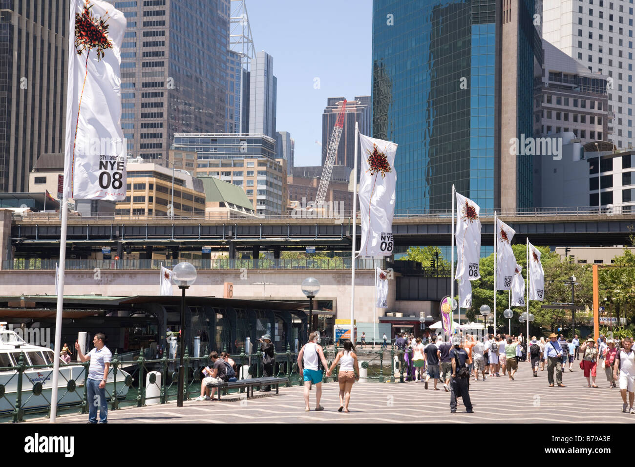 people walking along west circular quay, city of sydney has new years eve banners flying,sydney Stock Photo