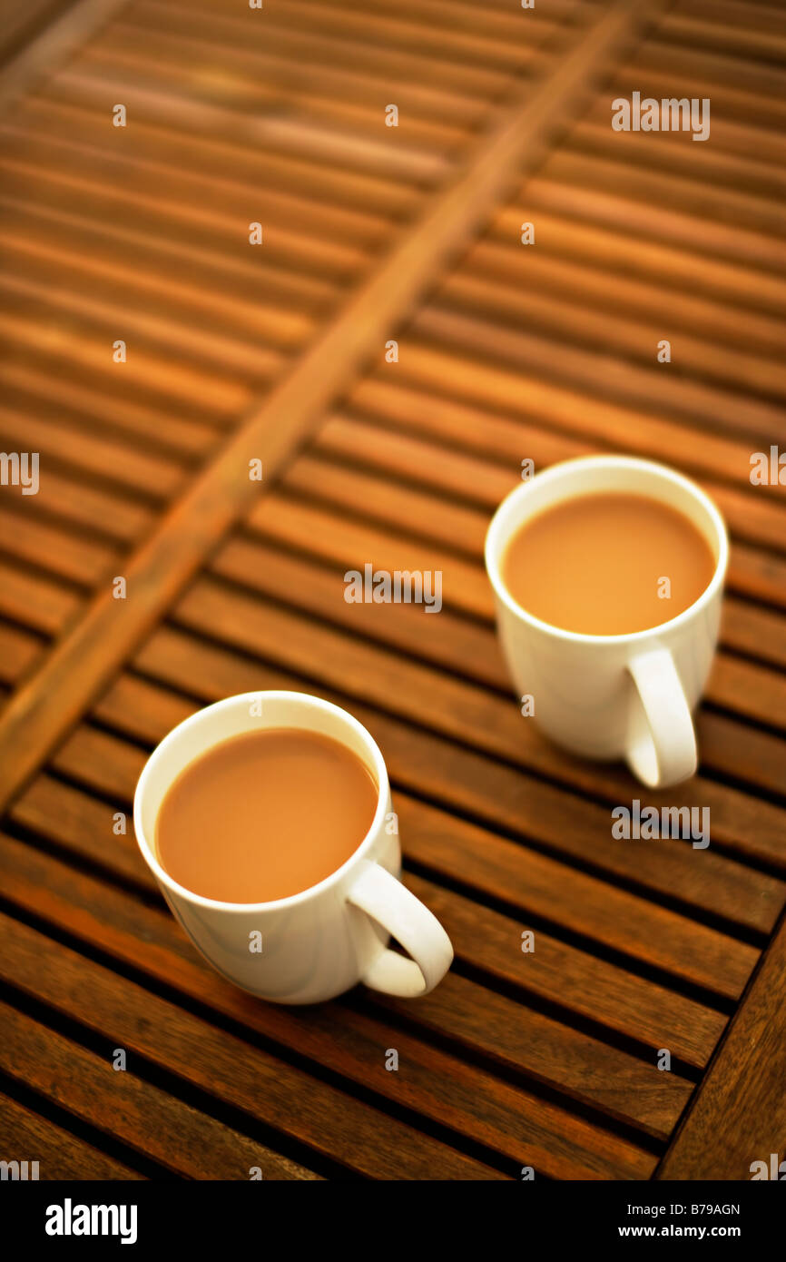 Two mugs of tea on a wooden garden table Stock Photo