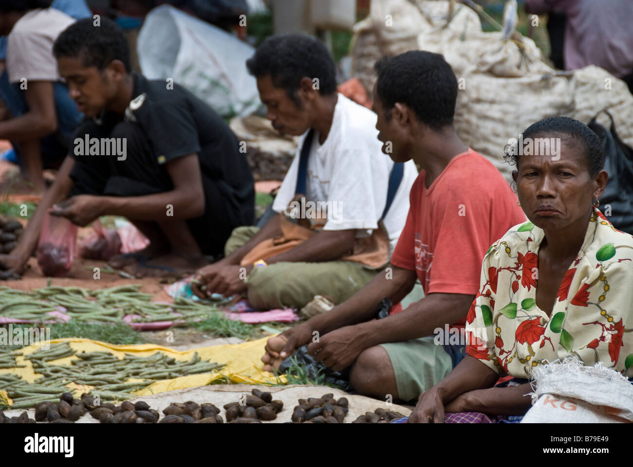 Vendors sit in Kapan market with one of them looking disapproving, West Timor, Indonesia Stock Photo