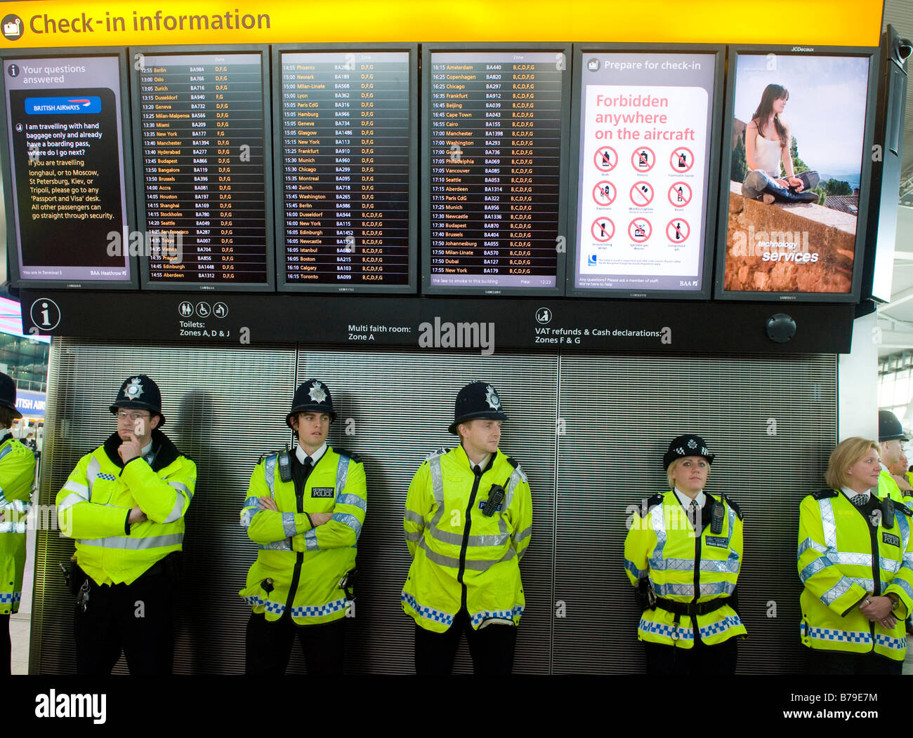 Police officers protecting  the Departures area inside Heathrow Airport Terminal 5 Stock Photo