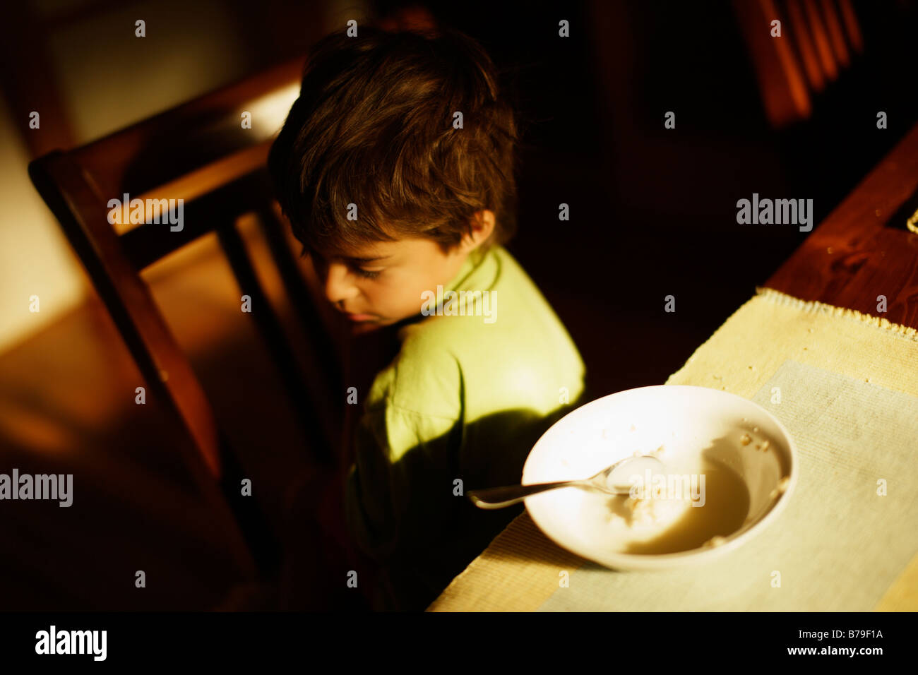 Six year old boy eating porridge at breakfast Stock Photo