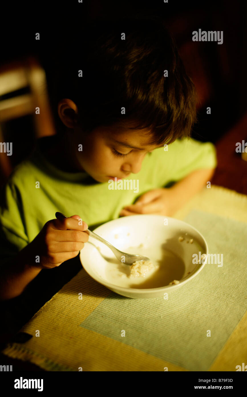 Six year old boy eating porridge at breakfast Stock Photo Alamy