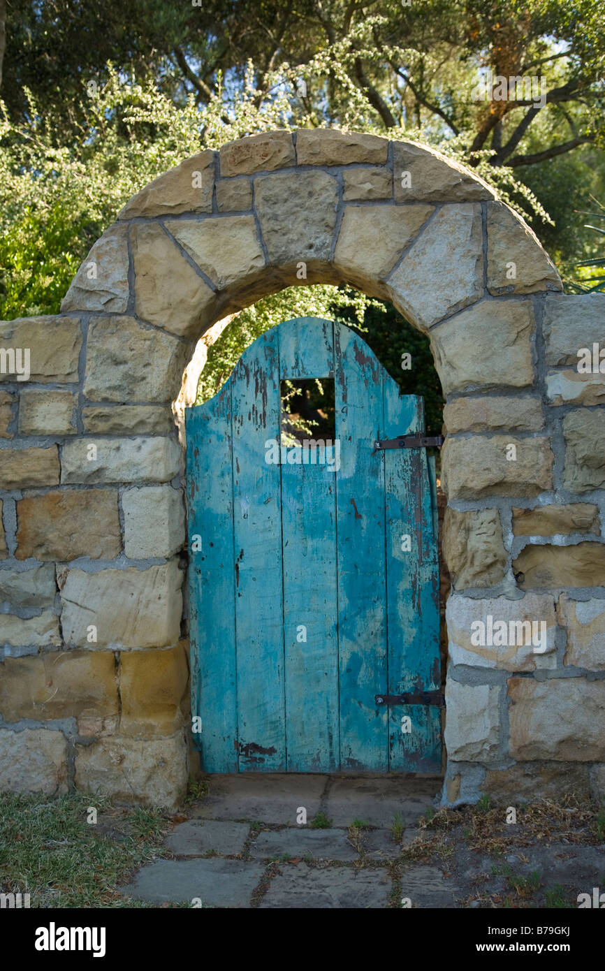 A stone archway with a weathered wooden turquoise door, near the old mission is typical of Santa Barbara California entryways. Stock Photo