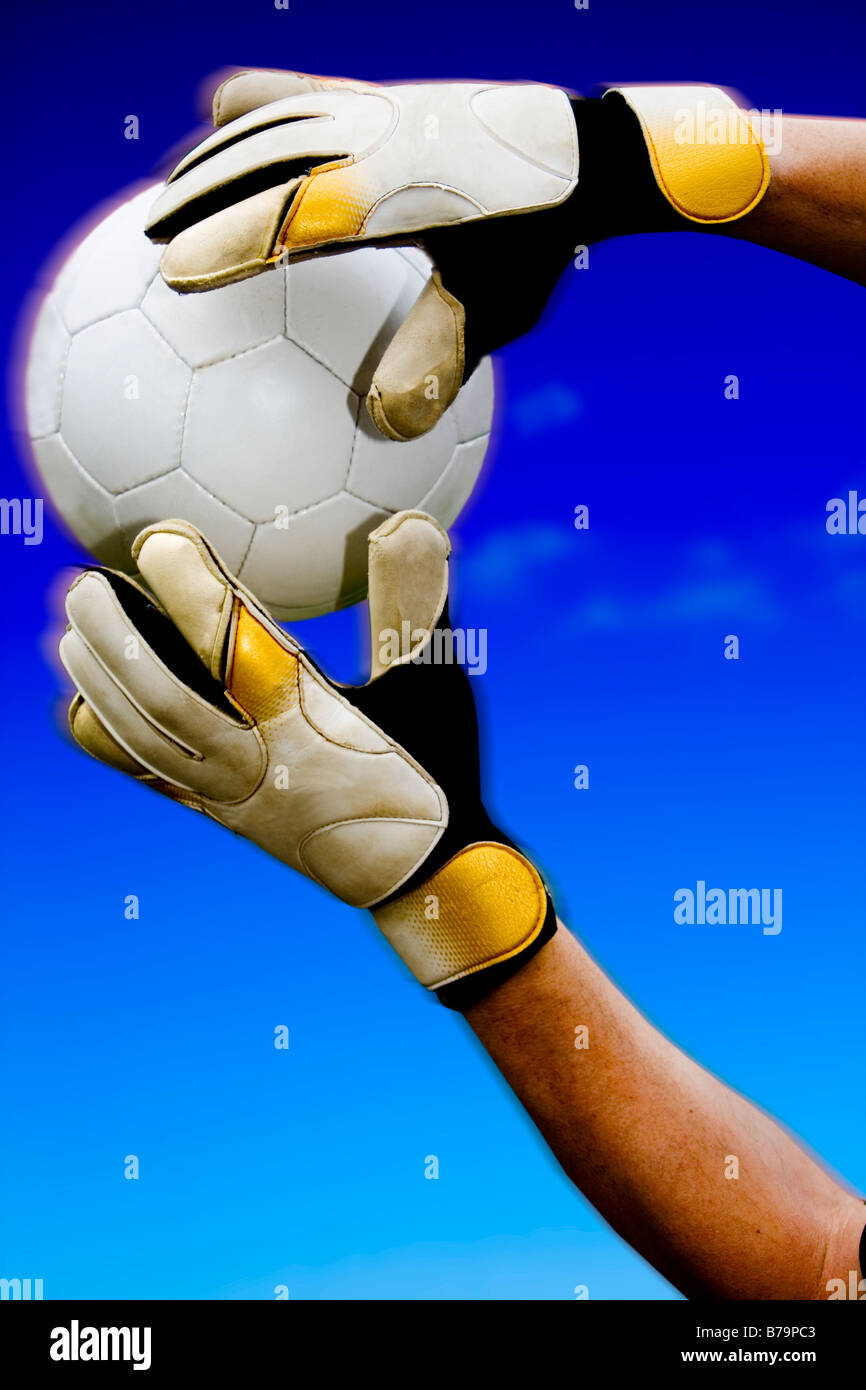 Goalkeepers hands saving ball in mid air Stock Photo