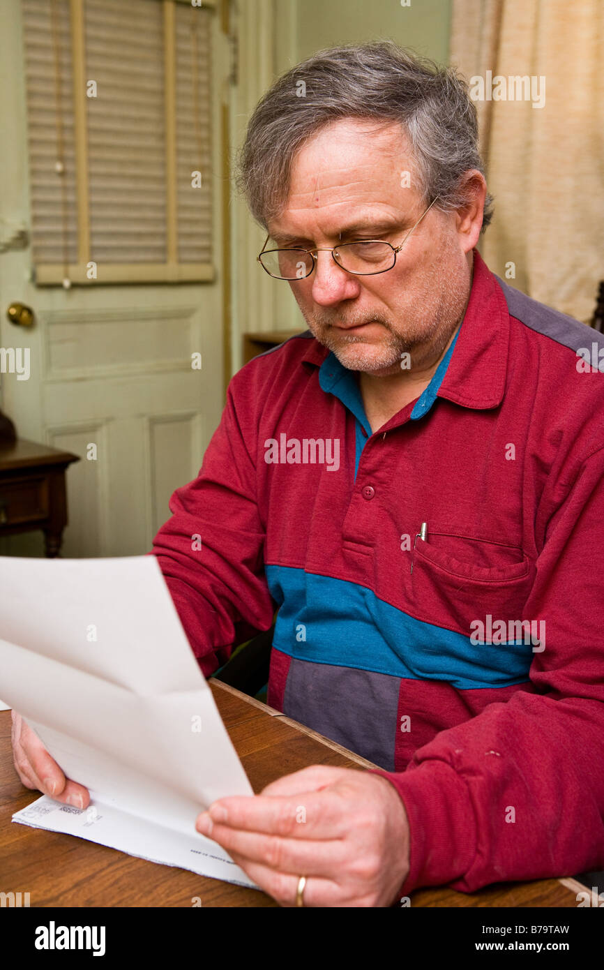 A man reviews a monthly bill Stock Photo