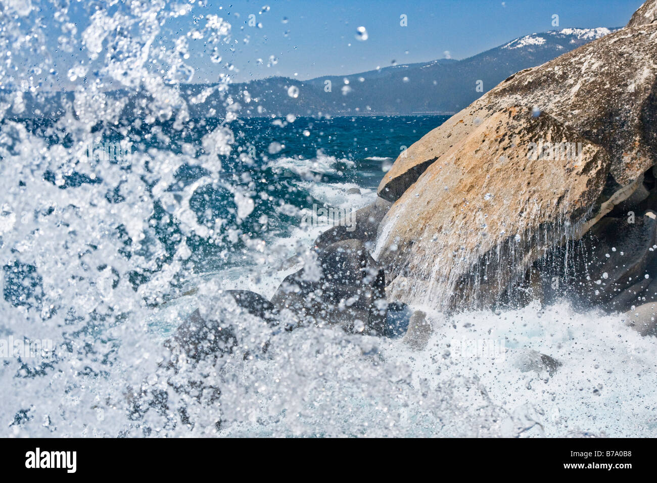 A rocky shoreline and breaking waves on the east shore of Lake Tahoe on a windy day in the spring Stock Photo