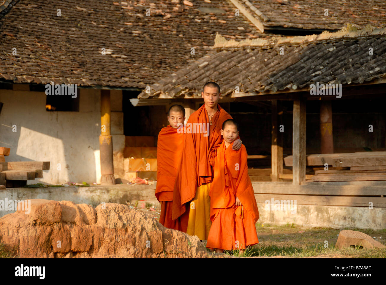 Buddhism, monk and two novices wearing orange robes, old Tai-Lue Temple Wat Luang, Ou Tai, Gnot Ou, Phongsali province, Laos, S Stock Photo