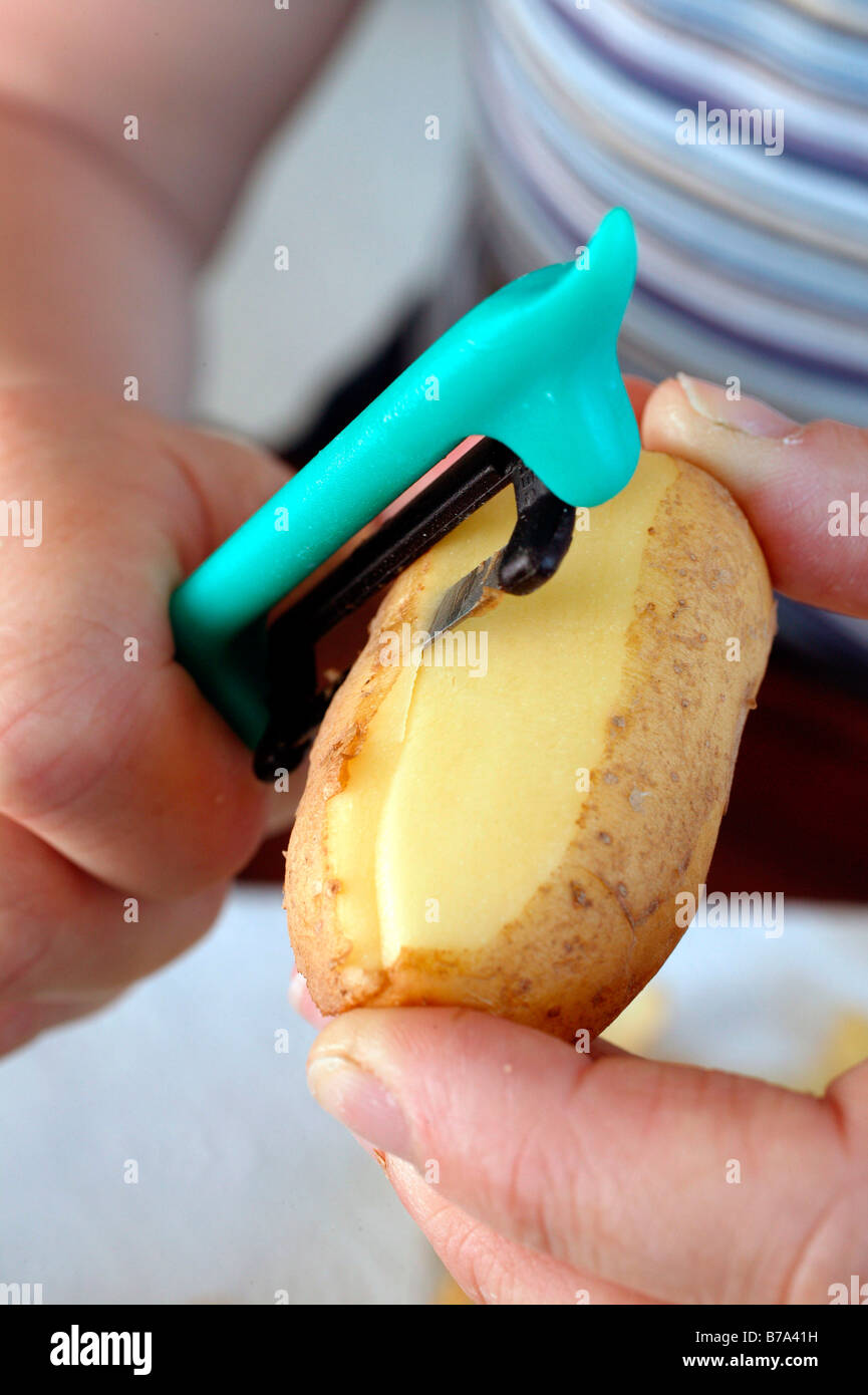 Hand peeling potatoes Stock Photo