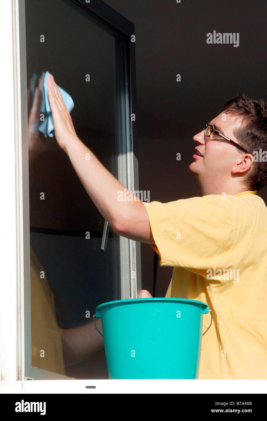 Young man cleaning windows Stock Photo