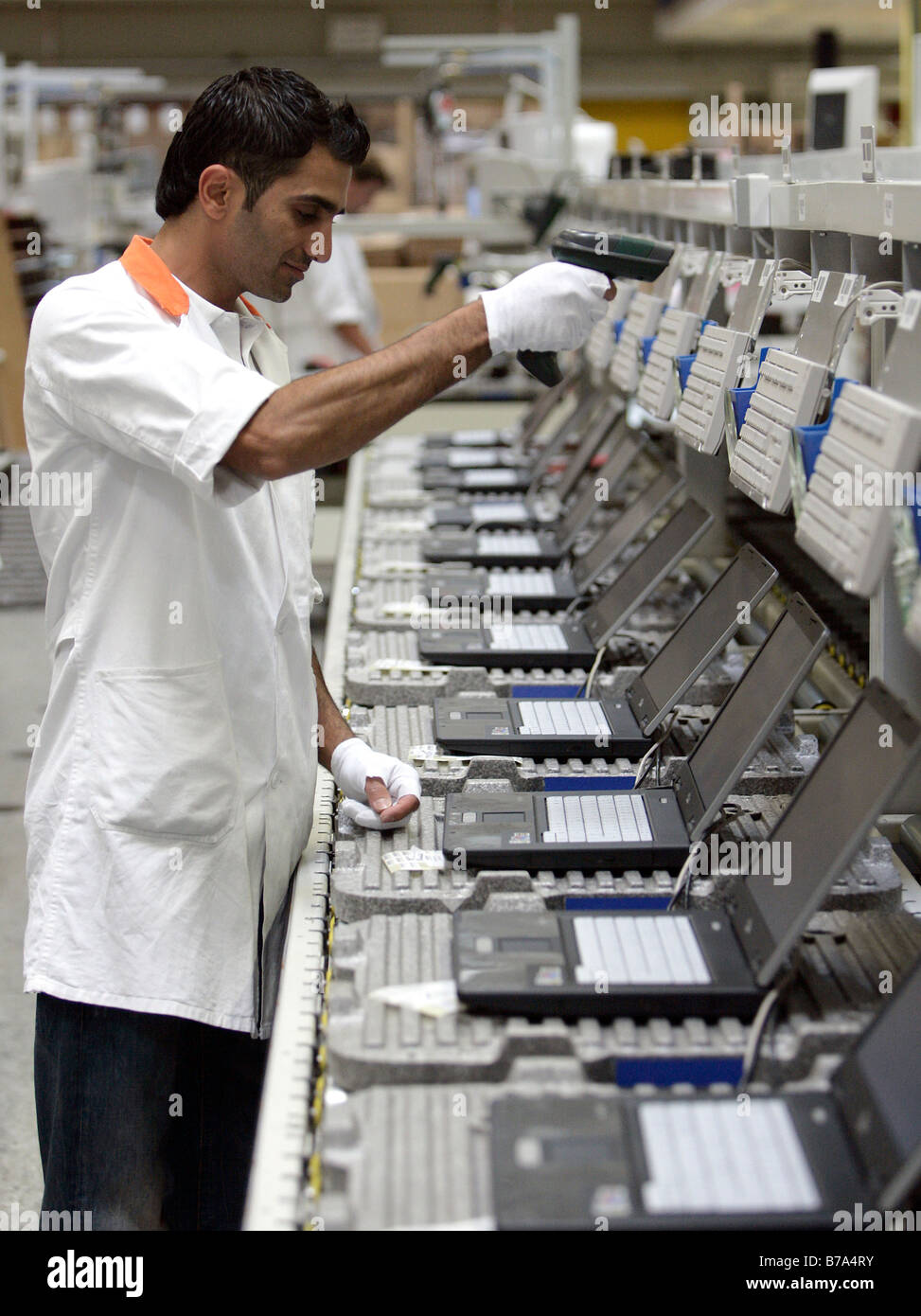 Employee of the computer production at the function test, final inspection of a notebook at the Fujitsu Siemens GmbH in Augsbur Stock Photo