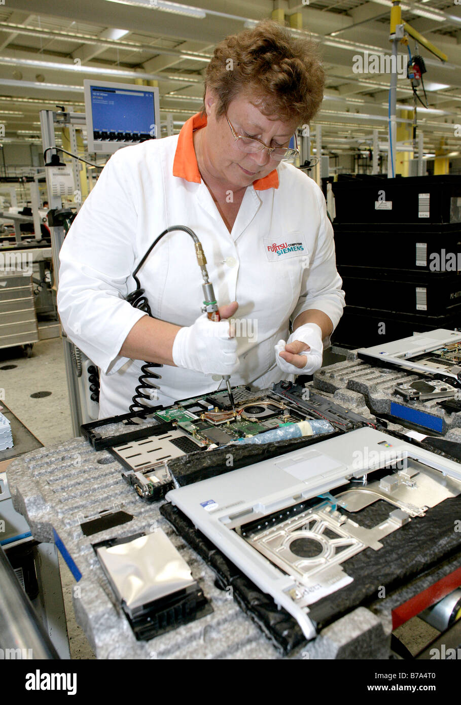 Employee of the computer production installing the mainboard into a notebook, at the Fujitsu Siemens GmbH in Augsburg, Bavaria, Stock Photo