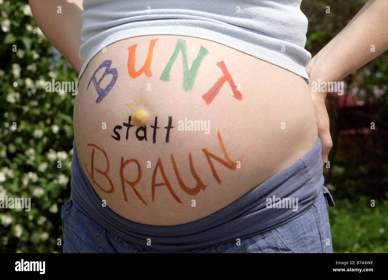 'Bunt statt Braun', colourful instead of brown, written on a belly, pregnant woman demonstrating against an assembly of the pol Stock Photo
