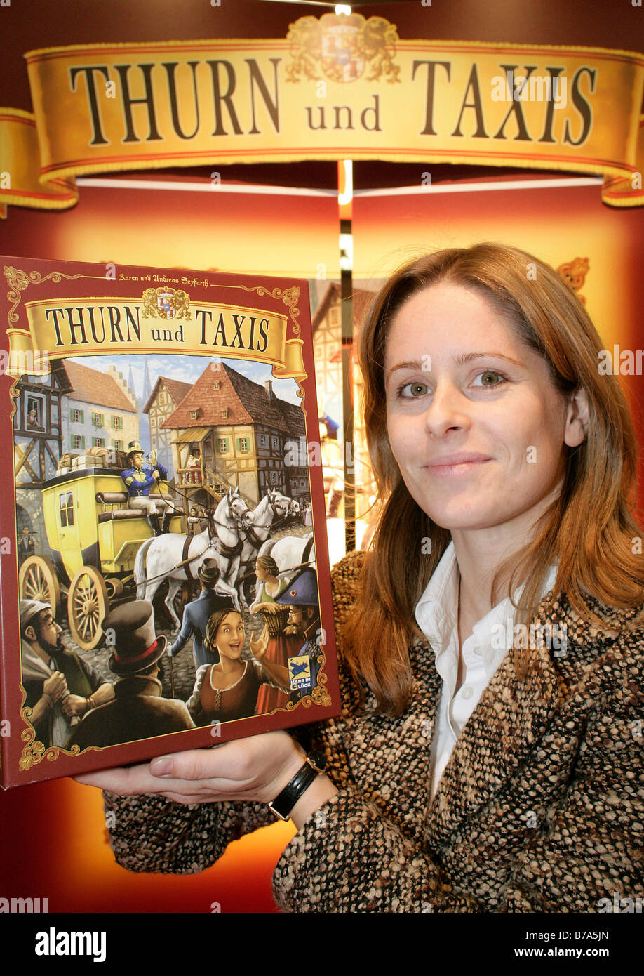 Schmidt Spiele employee indicating a game of strategy 'Thurn and Taxis' by Hans-im-Glueck-Verlag, at the Nuremberg Internationa Stock Photo