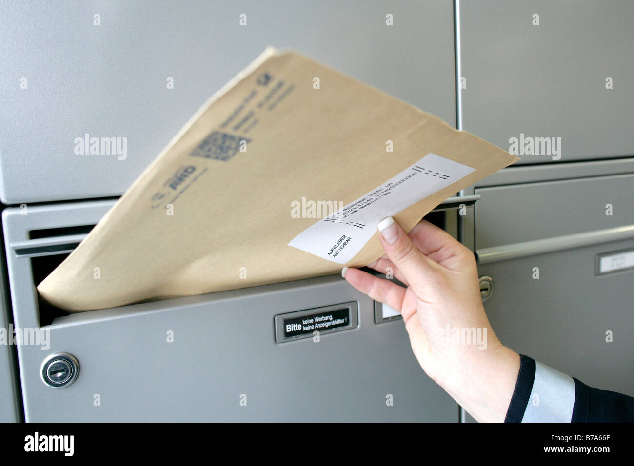 Hand of a mailwoman of the Deutsche Post AG, German post, delivering mail, Regensburg, Bavaria, Germany, Europe Stock Photo