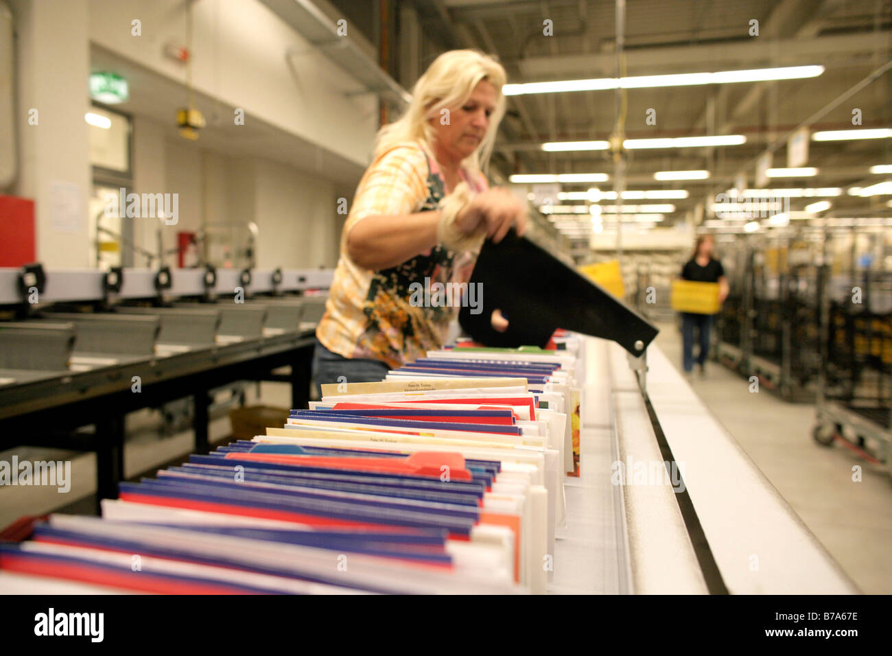 Employee of the Deutsche Post AG, German post, working on a machine that sorts the letters into the right order according to ro Stock Photo