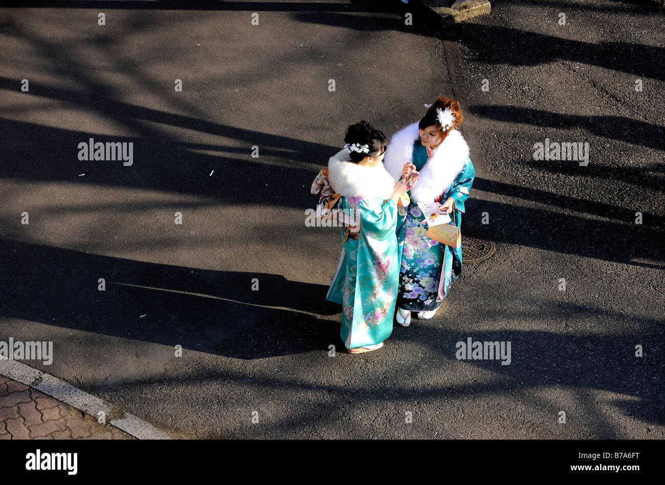 Two kimono clad 20 year old Japanese women look at photos on a camera monitor during an event to mark Coming of Age Day Stock Photo