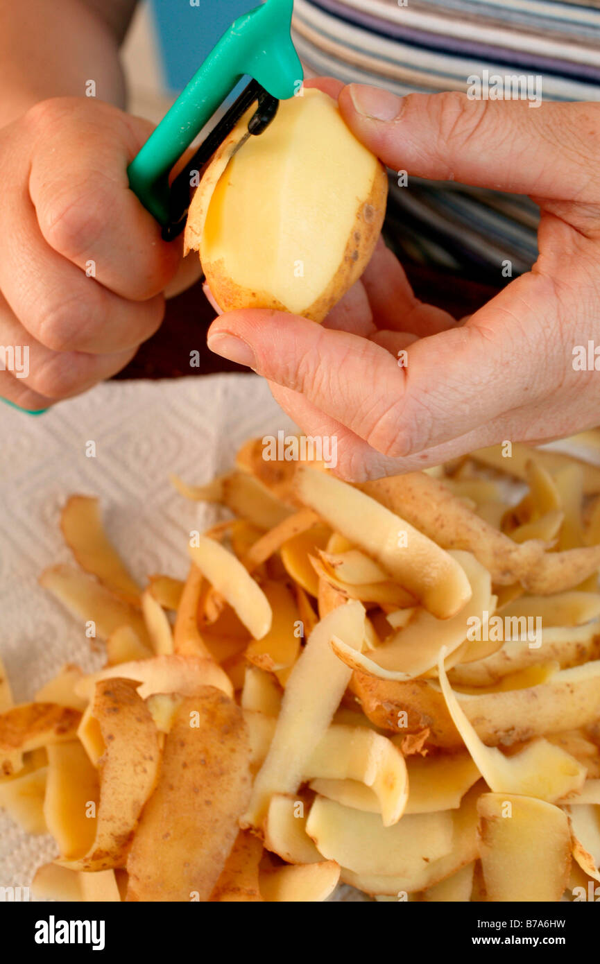 Hand peeling potatoes Stock Photo