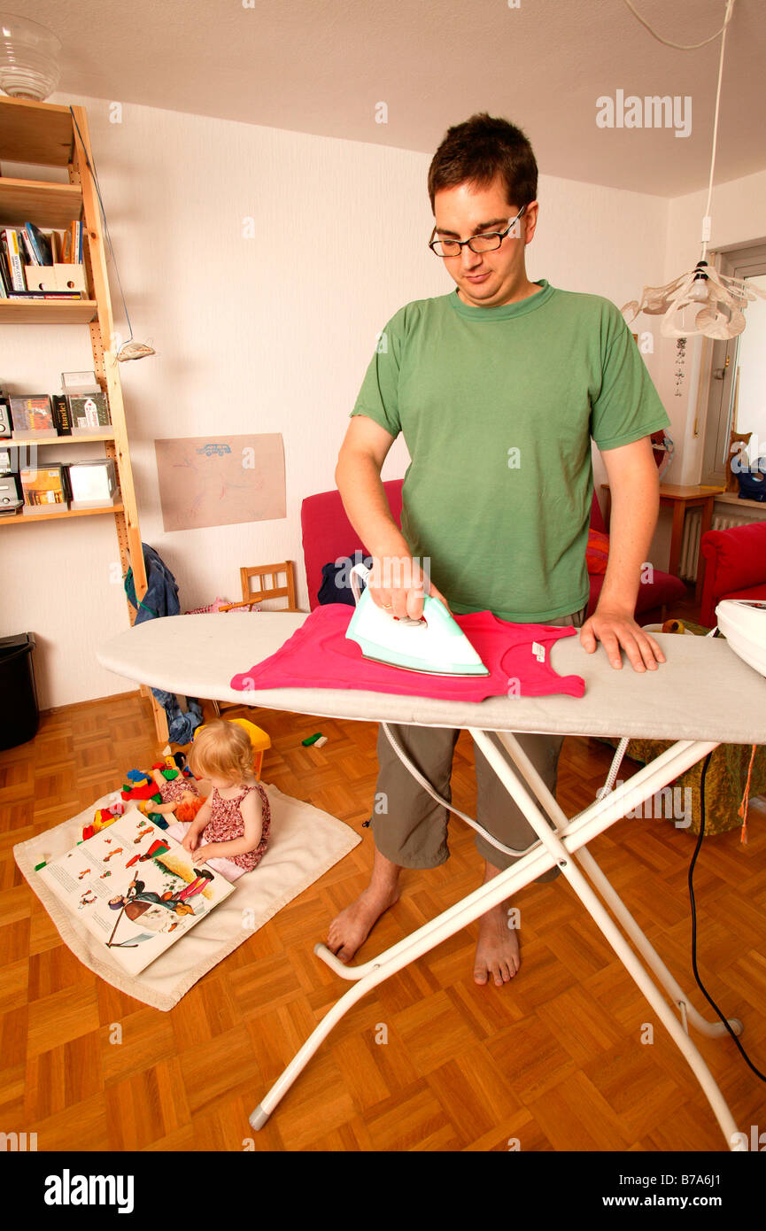 Man ironing and his child Stock Photo