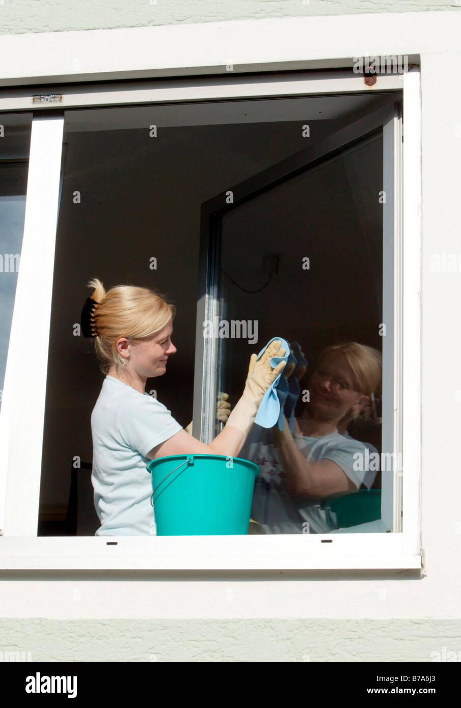Young woman cleaning windows Stock Photo