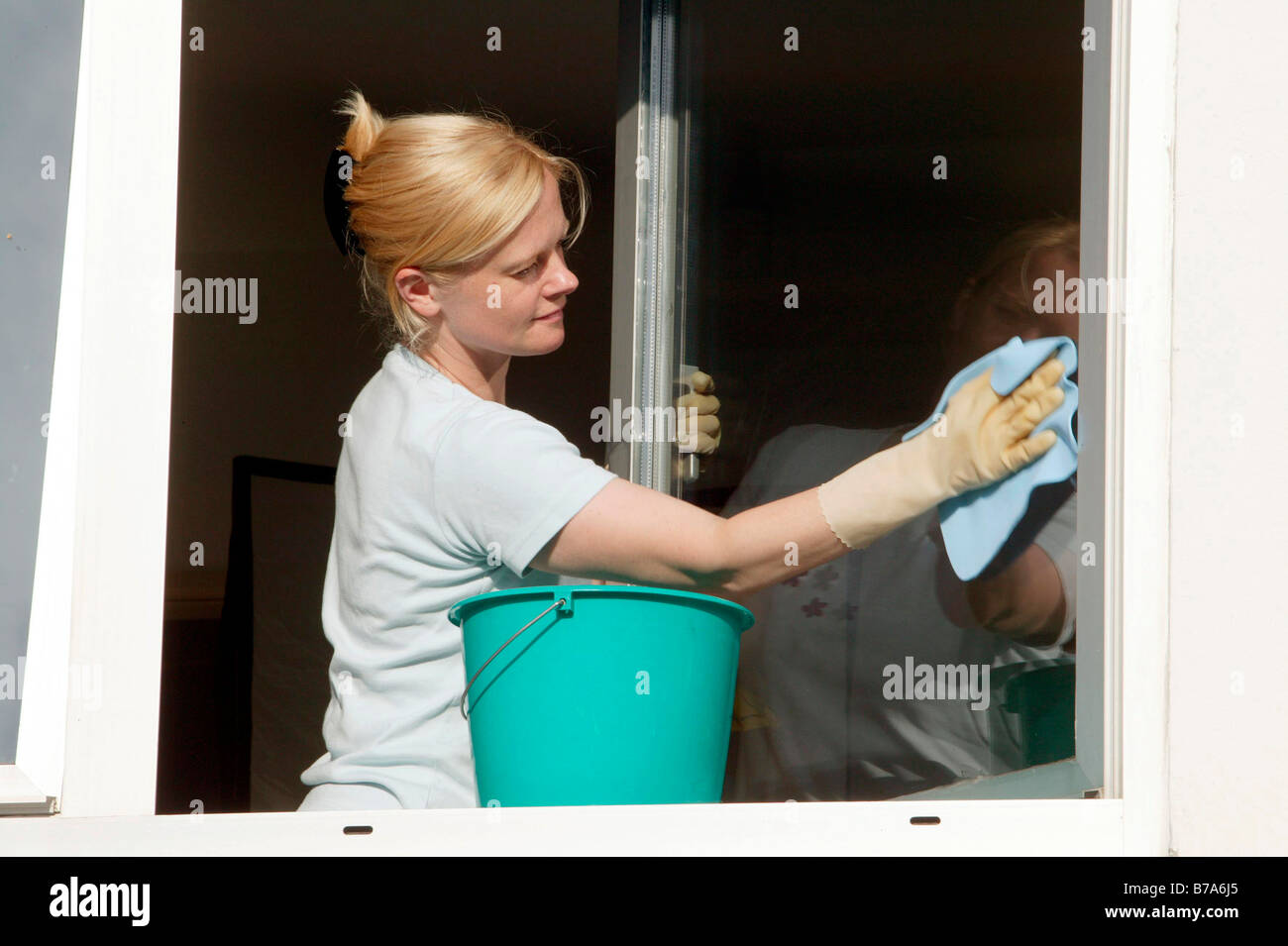 Young woman cleaning windows Stock Photo
