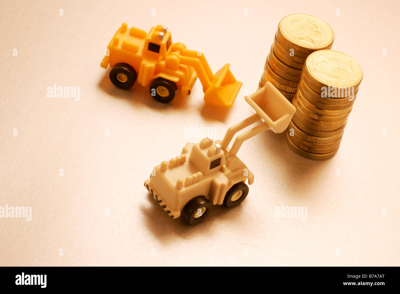 Miniature tractors and coins Stock Photo