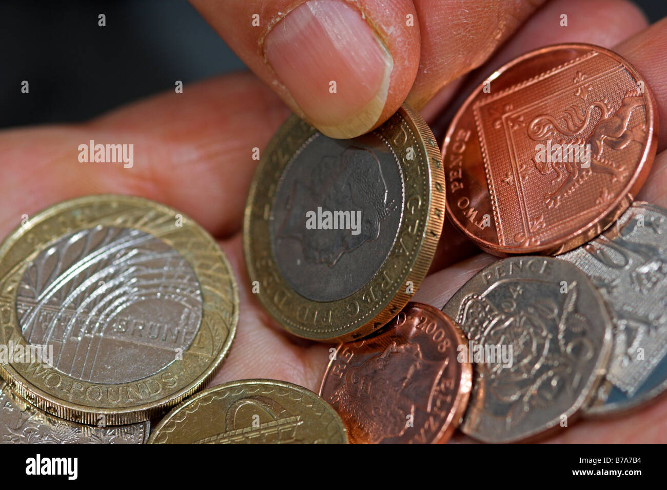 Closeup fingers of middle aged woman counting out change in her hand British Stock Photo