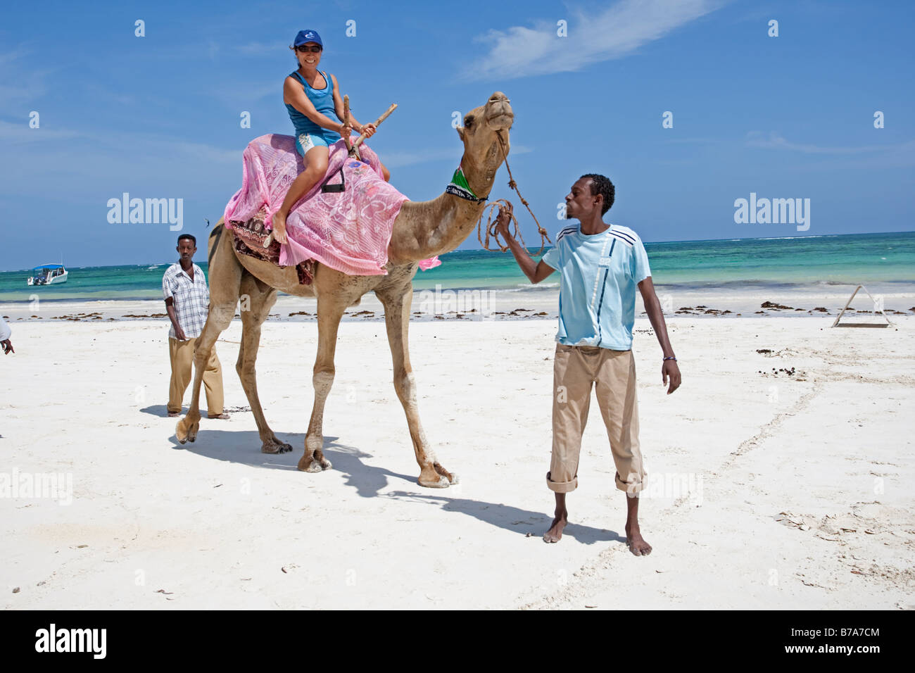 Japanese woman tourist riding camel on sands Diani Beach Southern Mombasa Kenya Stock Photo