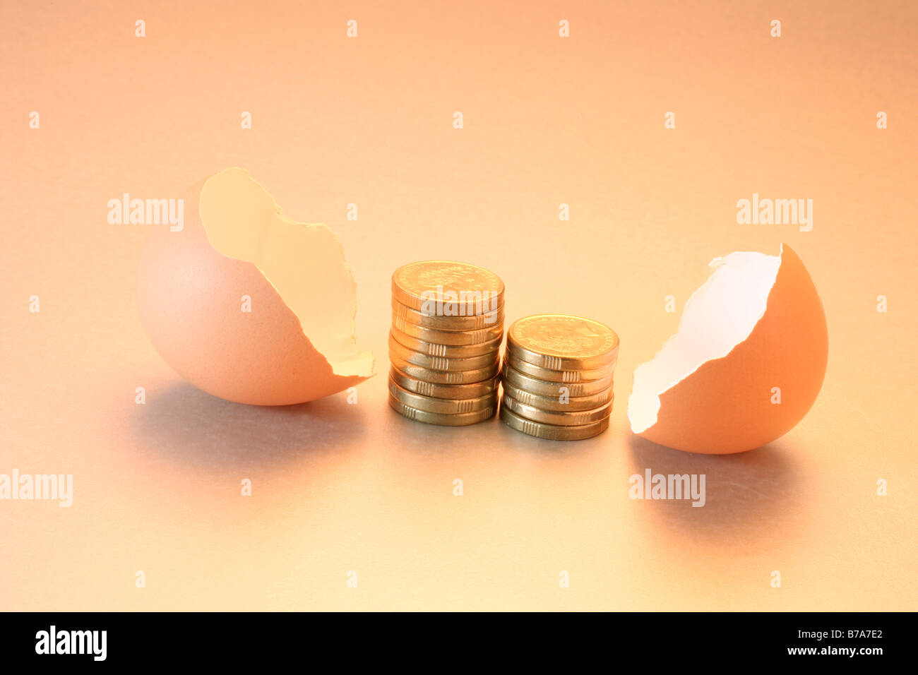 Coins between broken egg shells Stock Photo