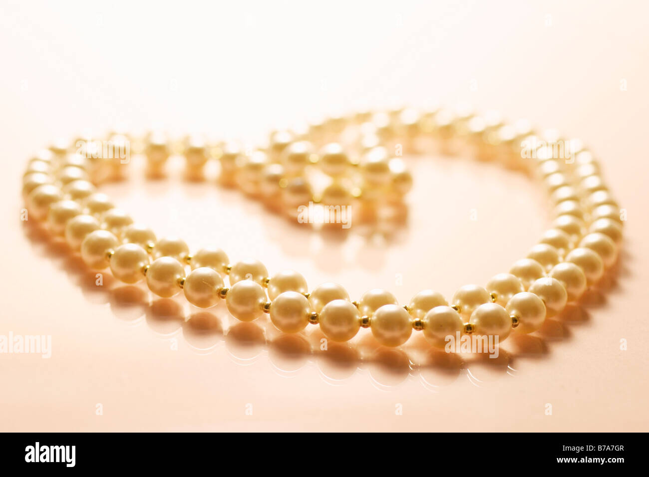 Pearl necklace draped in heart-shape Stock Photo