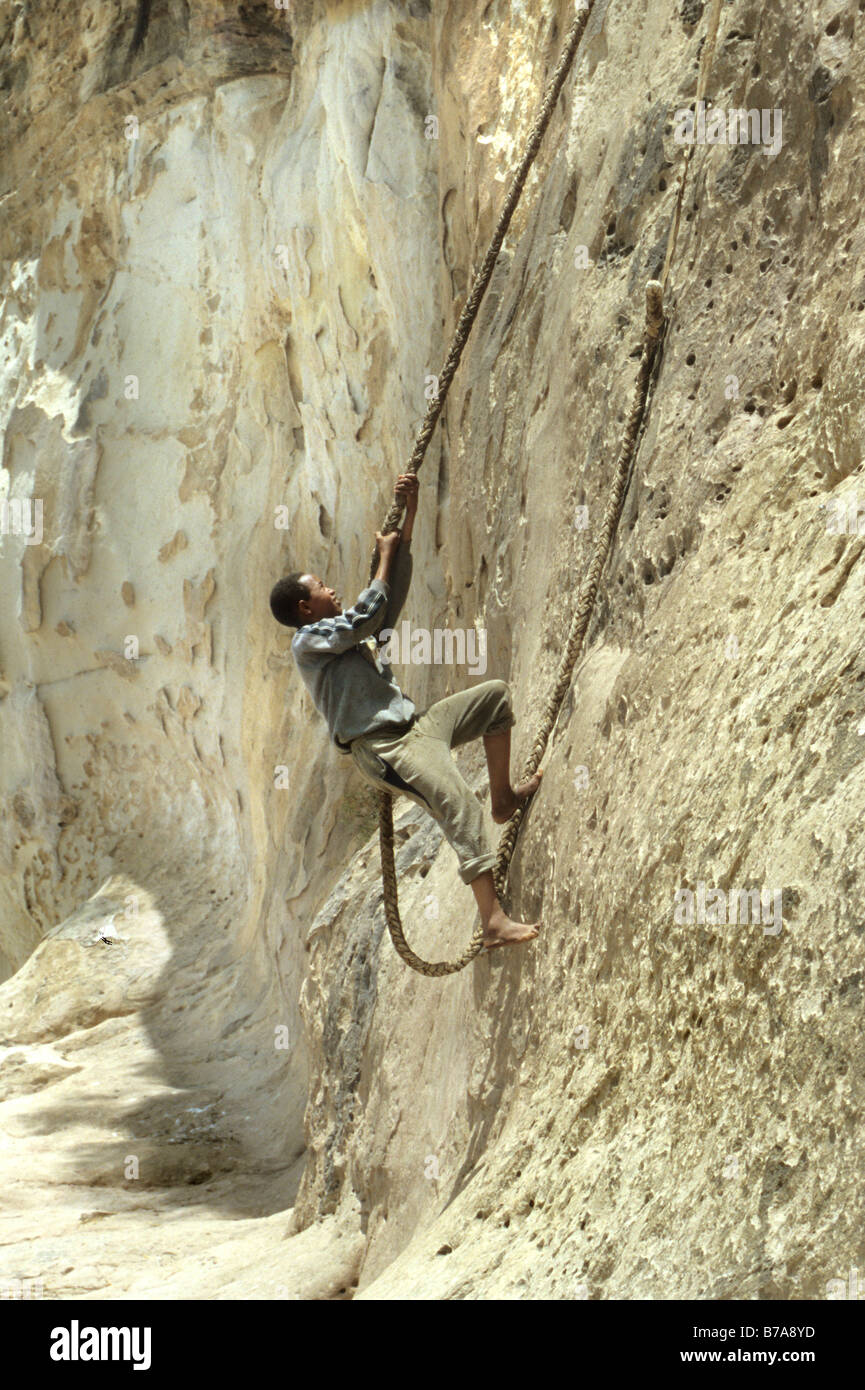 Pilgrim climbing a rope ladder to the Debre Damo cliff monastery Stock