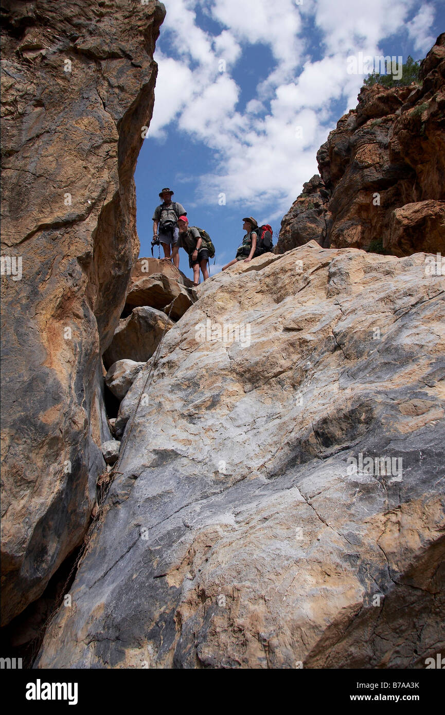 Hikers on the Naukluft hiking trail looking down a steep rock cliff Stock Photo
