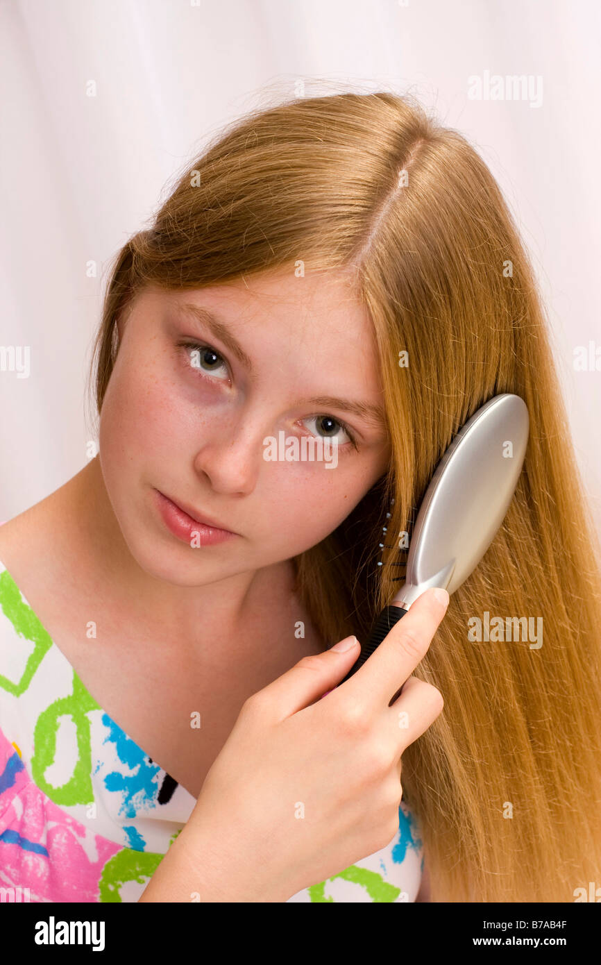 Seventeen year old girl brushing her hair Stock Photo