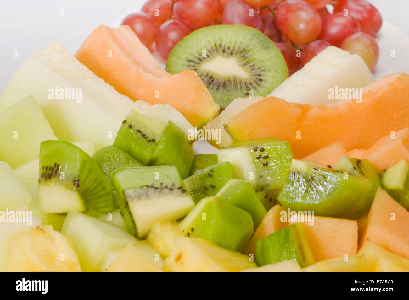 Sliced exotic fruit, sugar melon, honeydew melon, pineapple, kiwi and grapes Stock Photo
