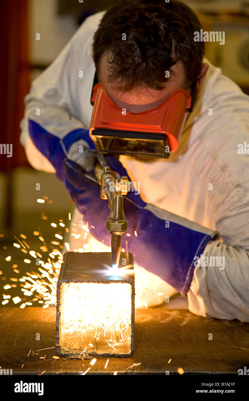 Welder using an acetylene torch to cut through a metal box Focus on the torch All work depicted